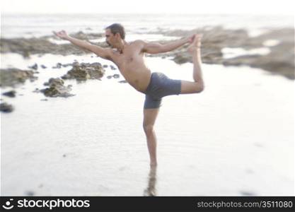 Man Practicing Yoga On The Beach