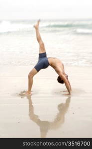 Man Practicing Yoga On The Beach