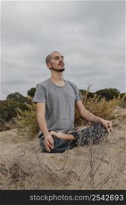 man practicing yoga outdoors