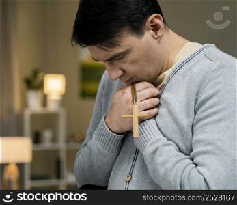 man praying with wooden cross