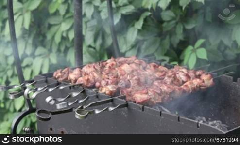 Man prepares pork shashlik on skewers