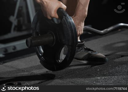 Man preparing barbell at fitness club