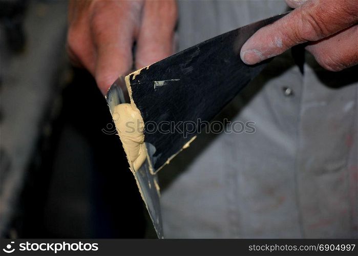Man preparing filler in a vehicle repair shop