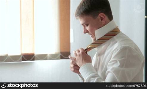 man preparing for his day at work tying necktie