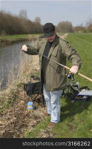 Man preparing his angling gear for a fishing session