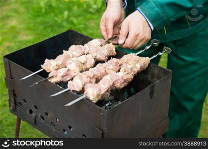 Man preparing meat on the grill, selective focus