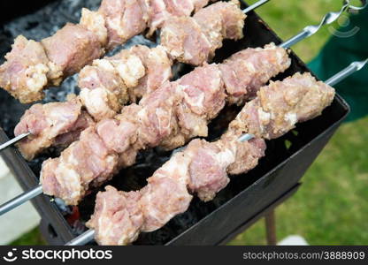 Man preparing meat on the grill, selective focus, top view