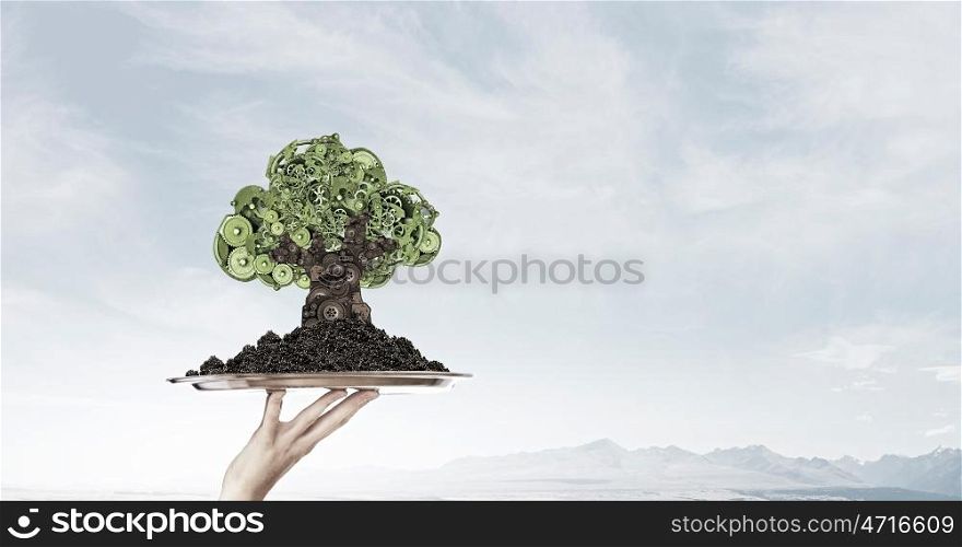 Man presenting green concept on tablet. Hand of businessman showing tablet with green gears tree on screen
