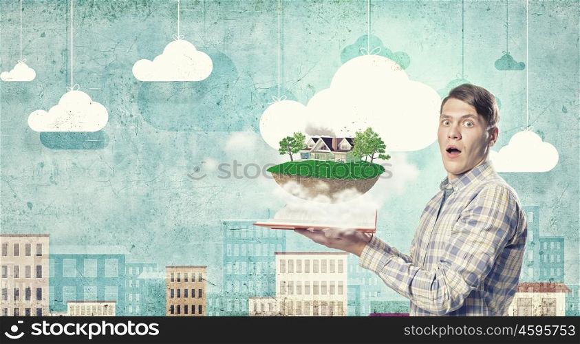 Man presenting green eco life . Young man in casual holding opened book with green concept