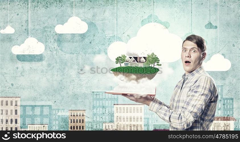 Man presenting green eco life . Young man in casual holding opened book with green concept