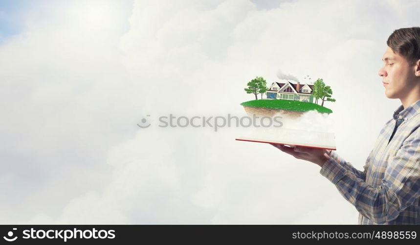 Man presenting green eco life . Young man in casual holding opened book with green concept