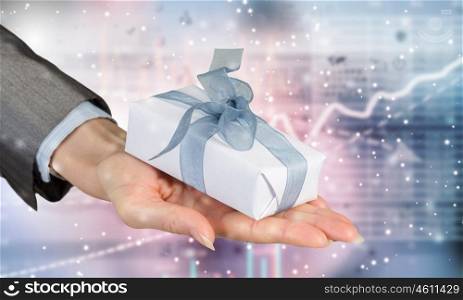 Man presenting his gift. Hand of elegant man holding gift box in palm