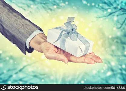 Man presenting his gift. Hand of elegant man holding gift box in palm