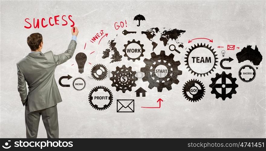 Man presenting teamwork concept. Back view of businessman standing with back and drawing gears mechanism