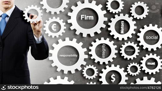 Man presenting teamwork concept. Close view of businessman standing with back and drawing gears mechanism