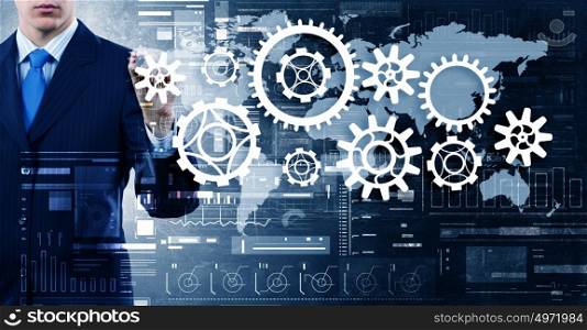 Man presenting teamwork concept. Close view of businessman standing with back and drawing gears mechanism
