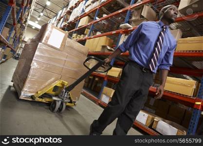 Man Pulling Pallet In Warehouse