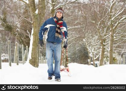 Man Pulling Sledge Through Winter Landscape