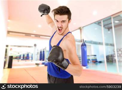Man punching with black boxing gloves at the gym