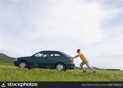 Man pushing his automobile with empty fuel tank
