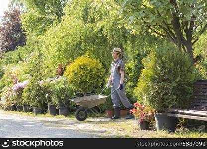 Man pushing wheelbarrow at garden
