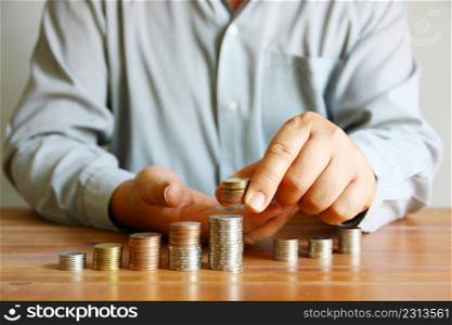 man put coins on group of coin stack , man plan saving money concept