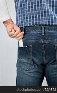 man puts an empty white paper business card in his back jeans pocket, close up
