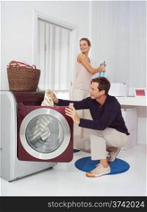 Man puts clothes into the washing machine