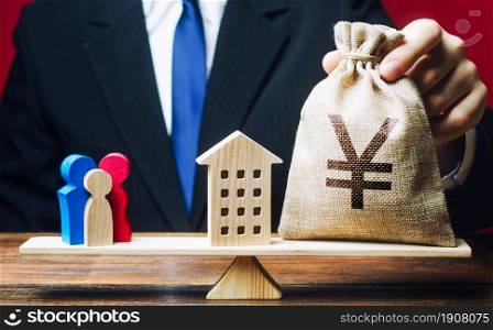 Man puts Yen yuan money bag and house on scales with a family. Mortgage, debt burden. Assistance with housing and financing for young families to stimulate childbirth demographic population growth.
