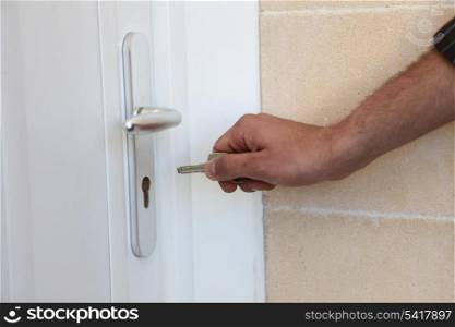 Man putting a key in his front door