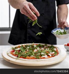 man putting arugula pizza dough. High resolution photo. man putting arugula pizza dough. High quality photo