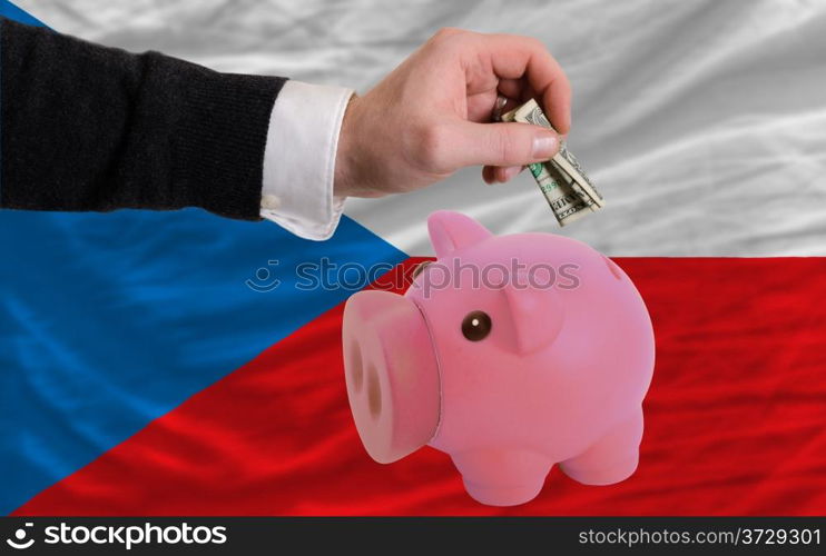 Man putting dollar into piggy rich bank national flag of czech in foreign currency because of inflation