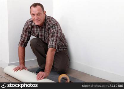 Man putting down linoleum flooring
