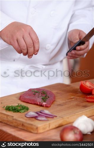 Man putting herbs on a piece of meat