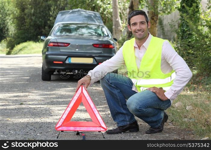 Man putting out a hazard triangle