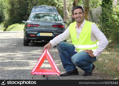 Man putting out a hazard triangle