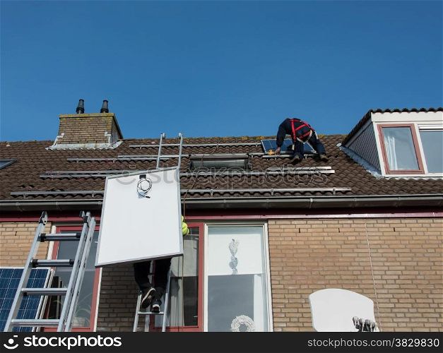 man putting the solar panel to the metal construction on the roof