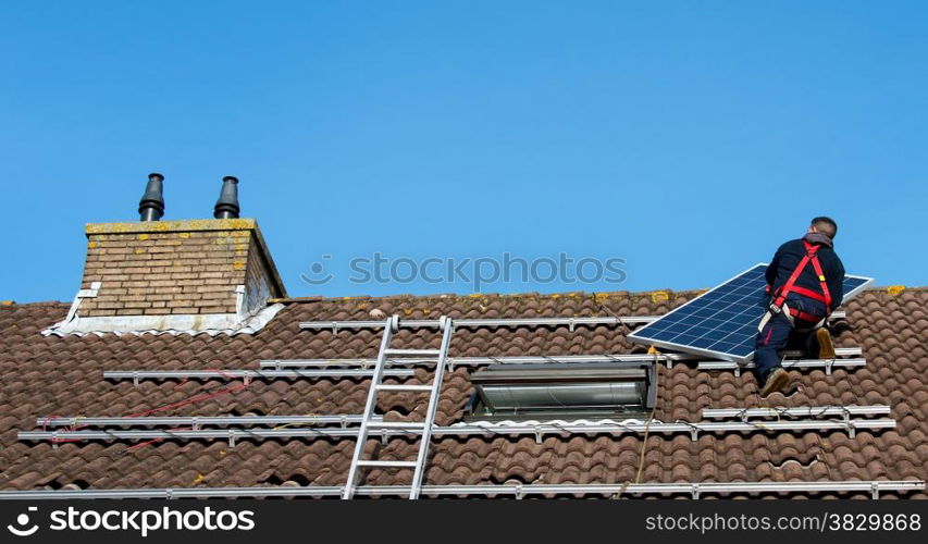 man putting the solar panel to the metal construction on the roof