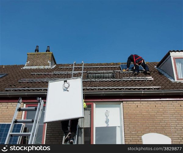 man putting the solar panel to the metal construction on the roof