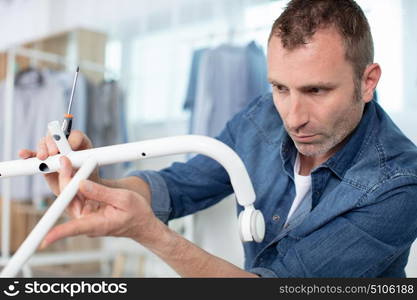 man putting together clothe rack