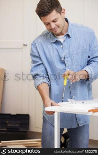 Man Putting Together Self Assembly Furniture At Home