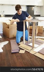 Man Putting Together Self Assembly Furniture In New Home