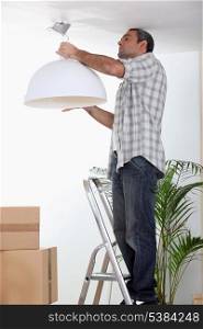 Man putting up a ceiling light