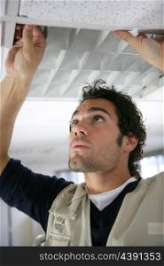 Man putting up a suspended ceiling