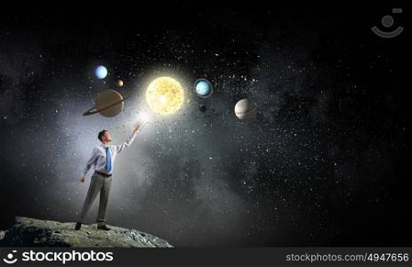Man reaching hand with book. Young businessman with book and planets of space spinning around
