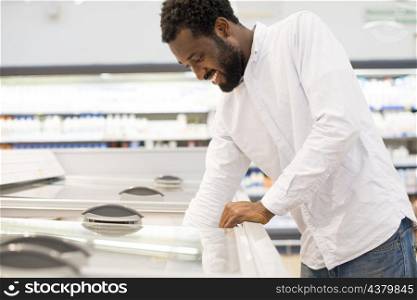 man reaching out into supermarket zer
