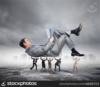 Man read book. Young businessman lying and reading book supported by colleagues