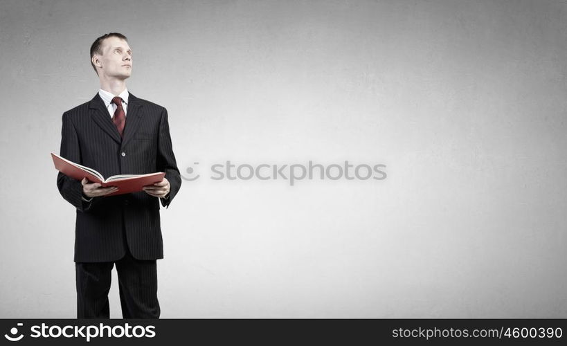 Man read book. Young businessman with red book in hands