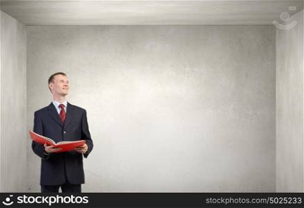 Man read book. Young businessman with red book in hands