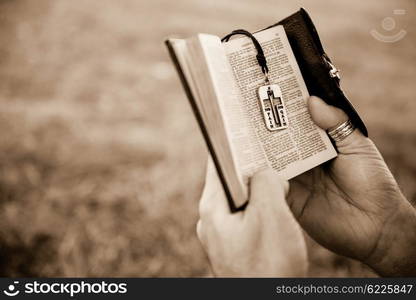 Man reading a bible outside